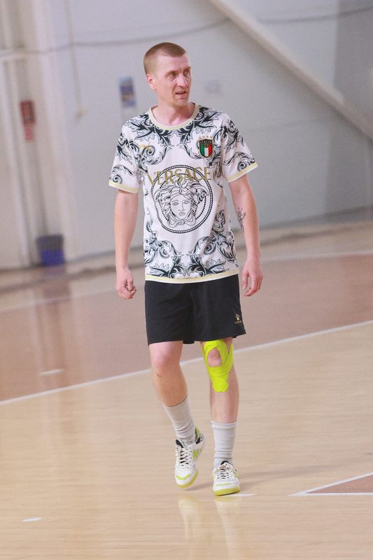 An EasyChamp player in a patterned white shirt carrying the ball out of defence in a Minsk futsal hall.