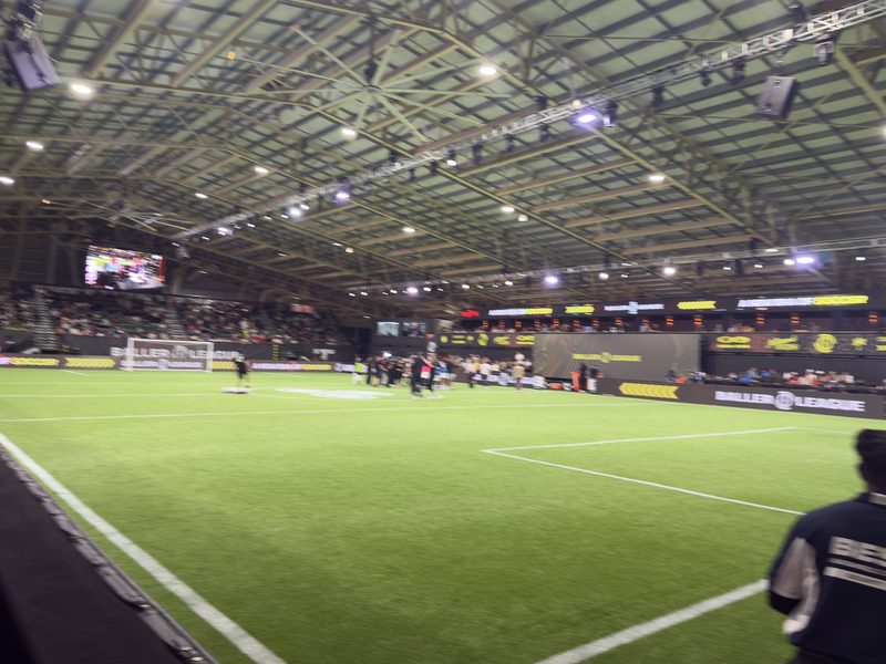 The empty green pitch and stand of the Baller League Miami arena before a match.