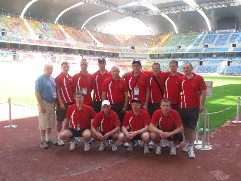 The full Belarus delegation in red team polo shirts lined up on the running track of a stadium in Kayseri.