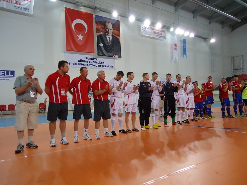 Two futsal teams lined up facing the officials under national flags before a match in Kayseri.
