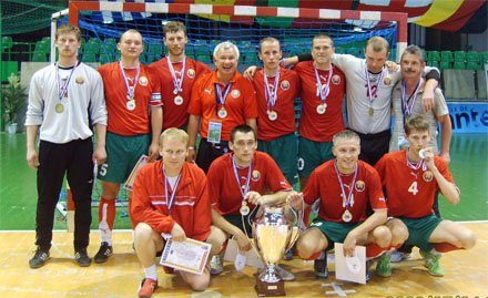 The Belarus visually impaired national futsal team sitting behind the cup with their medals after the 2009 European Championship in Nantes.