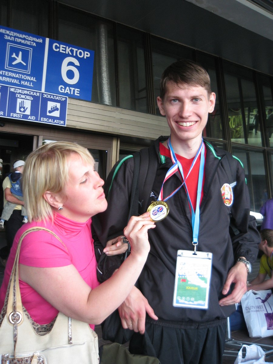 Anton Abyzov in a Belarus national tracksuit holding up the 2009 European Championship gold medal in an international arrivals hall on the day the squad came home.