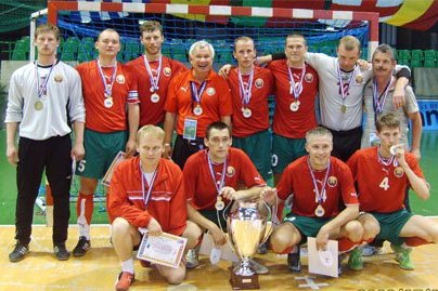 The Belarus visually-impaired national futsal team after winning the European Championship in Nantes, 2009, medals on and the cup in front.